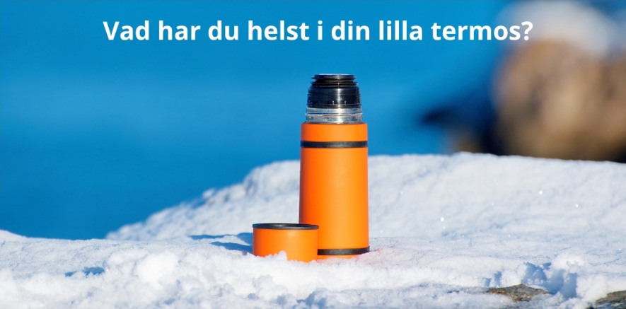 En orange liten termos som står på snö