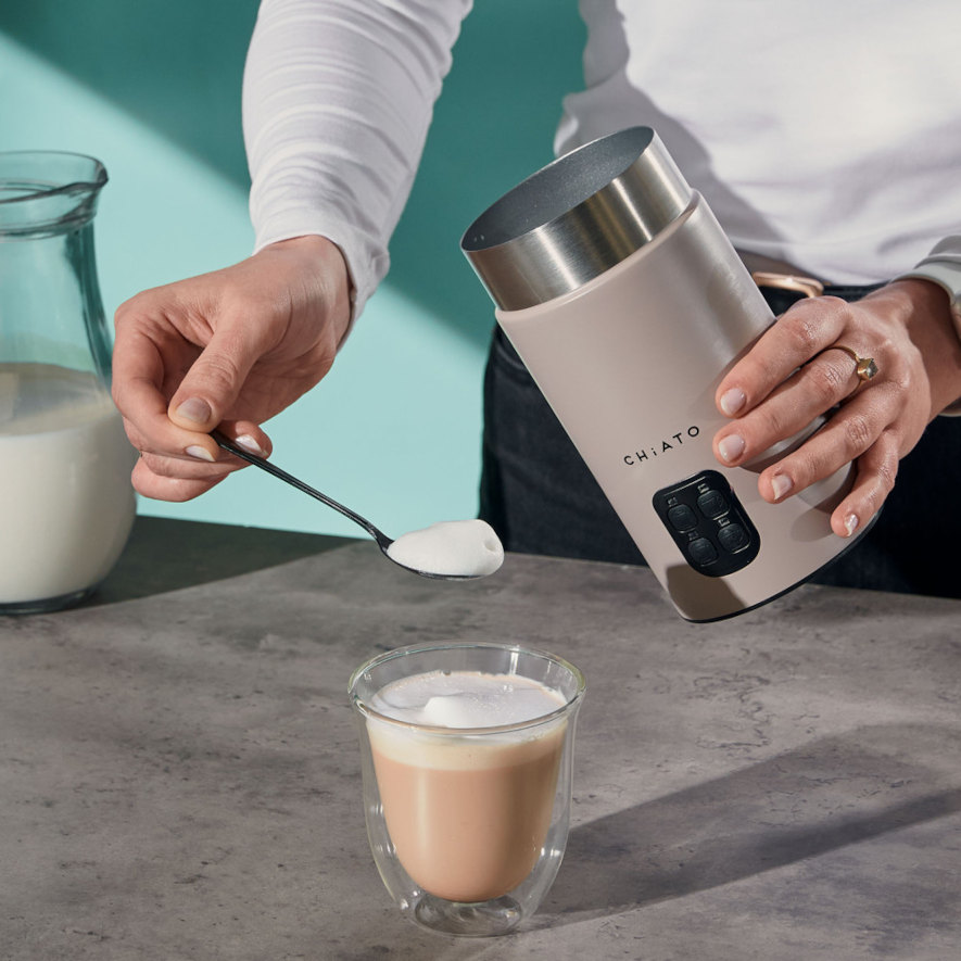 lägger skum vispad med chiato milkplay mjölkskummare ovanpå kaffet