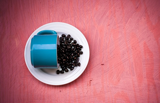 kaffebönor bredvid blå kopp
